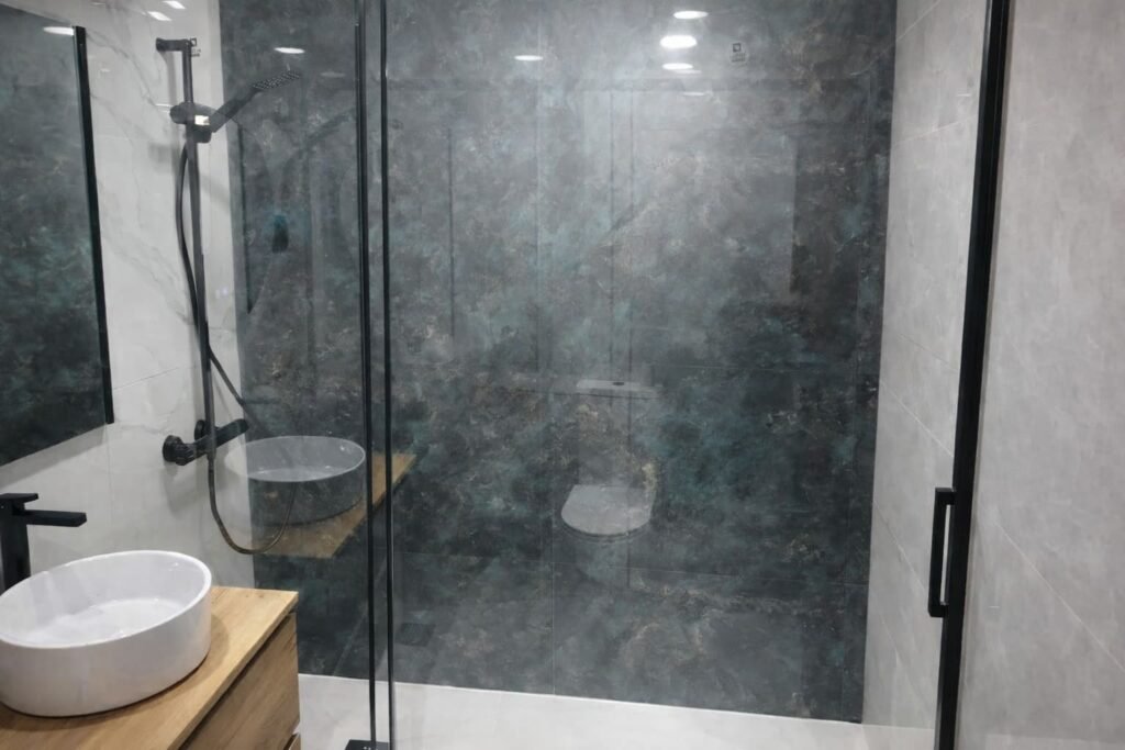 Mampara corredera negra en baño reformado en Leganés