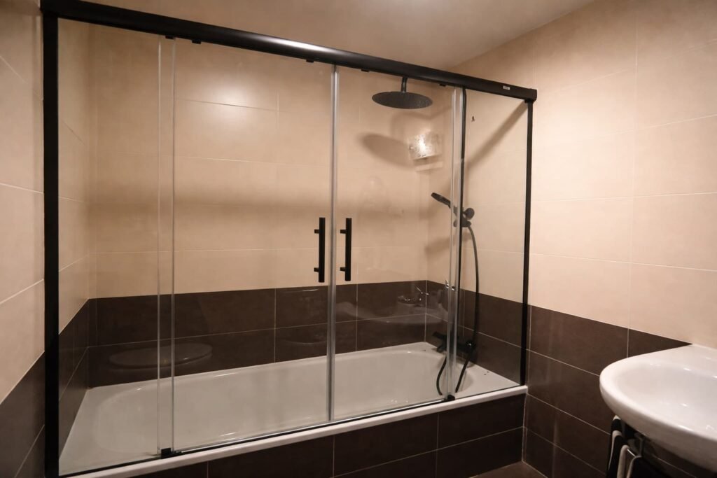 Mampara negra para bañera en baño reformado en Leganés
